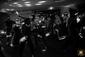 Image en noir et blanc capturant une danse magnifiquement chorégraphiée au Château de Vair à Vair sur Loire, en France, avec des bâtons lumineux et des lunettes.